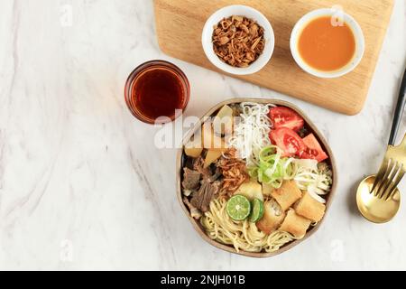 Soto Mie Bogor, klare Rindfleischsuppe mit Nudeln und Frühlingsrolle. Draufsicht mit Kopierbereich für Text oder Rezept Stockfoto