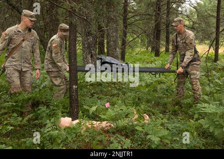 Soldaten der Bravo Kompanie, 1. Bataillon, 125. Infanterie-Regiment, Michigan National Guard, bringen einen Wurf mit, um eine Schaufensterpuppe während ihrer Such- und Genesungsübung am Northern Strike 22-2 in Grayling, Michigan, zu Bergen, 8. August 2022. Northern Strike konzentriert sich auf die Fähigkeit der Streitkräfte, die Krieger in jeder Umgebung des Kontinuums auszubilden, damit unsere Nation heute und morgen konkurrieren, abschrecken und gewinnen kann. Stockfoto