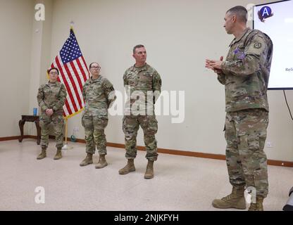 Oberstleutnant Ben Hines, Kaplan, Area Support Group-Kuwait, gibt dem Kaplan, Kaplan, 531. Hospital Center, Und SPC. Jessica Ramirez, Spezialist für religiöse Angelegenheiten, 531. Hospital Center, für ihre Unterstützung der Area Support Group-Kuwait und des gesamten Personals in Camp Arifjan, während einer monatlichen Zusammenkunft des Unit Ministry Teams in Camp Arifjan, Kuwait, 10. August 2022. Stockfoto