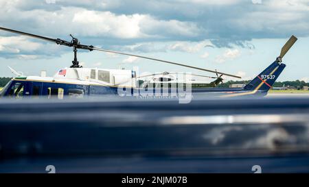 Ein VH-3D Sea King Hubschrauber, der der Marine Helicopter Squadron (HMX) 1, Joint Base Anacostia-Bolling, D.C., zugewiesen wurde, auf der Joint Base Andrews Fluglinie neben zwei H-1N Hueys, die der ersten Hubschrauberstaffel der Air Force (1 HS) zugewiesen wurden, Joint Base Andrews, Md., 8. August 2022. HMX-1 wurde am 1. Dezember 1947 als Versuchseinheit gegründet, die mit der Erprobung und Bewertung von Militärhubschraubern beauftragt war, als der Drehflügelflug noch in den Kinderschuhen steckte. 1 die Aufgabe von HS besteht darin, vorrangige Lufttransporte für zivile und militärische Führungspersönlichkeiten auf nationaler Ebene in der Nationalen Hauptstadtregion bereitzustellen. Stockfoto