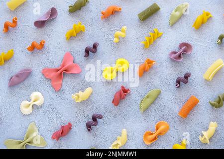 Muster. Verschiedene Arten und Formen italienischer Pasta auf Betonhintergrund. Trockener Nudelhintergrund. Draufsicht. Flach verlegt. Stockfoto