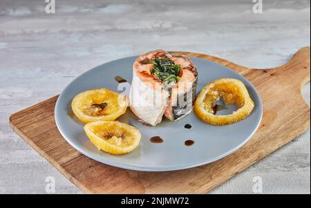 Lachs mit Spinat und gebackene Zitrone und Soße. Französische Gourmetküche. Stockfoto