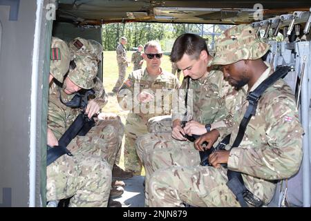 Soldaten, die dem 1-111. General Support Aviation Battalion, Florida National Guard, zugeteilt wurden, zeigen dem 7. Bataillon die Gewehre - London und die besten Soldaten des britischen Armee Reserve Infanterie Battalion des Südens, wie man ihre Sicherheitsgurte in einem UH-60 Blackhawk Hubschrauber anlegt für Northern Strike Training in Camp Grayling, Michigan, Am 9. August 2022. Northern Strike '22 bringt 7.400 Teilnehmer aus 19 Staaten und vier Koalitionsländern nach Nord-Michigan, um die Bereitschaft und Interoperabilität mehrkomponentiger, multinationaler und interinstitutioneller Partner zu validieren. (USA Army National Guard Video von S Stockfoto