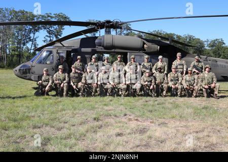 Das 7. Bataillon die Gewehre - London und das führende britische Armee Reserve Infanterie-Bataillon des Südens posieren für ein Gruppenfoto vor einem UH-60 Blackhawk Hubschrauber nach Abschluss der Flugzeugeinführungsschulung für Northern Strike '22, in Camp Grayling, Michigan, am 9. August 2022. Northern Strike '22 bringt 7.400 Teilnehmer aus 19 Staaten und vier Koalitionsländern nach Nord-Michigan, um die Bereitschaft und Interoperabilität mehrkomponentiger, multinationaler und interinstitutioneller Partner zu validieren. Stockfoto