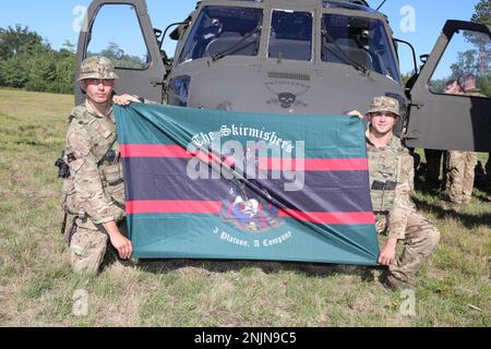 Schütze Ryan Murphy, links, Und Rifleman Michael Thomas, Infanteers mit dem 7. Bataillon The Rifles - London und dem Premier British Army Reserve Infanterie-Bataillon des Südens, halten die Flagge ihrer Firma für ein Foto nach Abschluss des Flugzeugtrainings für Northern Strike '22 in Camp Grayling, Michigan, am 9. August 2022. Northern Strike '22 bringt 7.400 Teilnehmer aus 19 Staaten und vier Koalitionsländern nach Nord-Michigan, um die Bereitschaft und Interoperabilität mehrkomponentiger, multinationaler und interinstitutioneller Partner zu validieren. Stockfoto