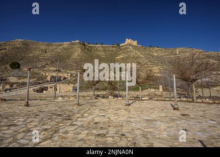 Überreste der Altstadt von Mequinenza, die nach dem Bau des Ribarroja-Reservoirs zerstört wurden. Im Hintergrund befindet sich die Burg Mequinenza (Spanien) Stockfoto