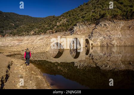 Die mittelalterliche Brücke Querós im Susqueda-Reservoir, die nach dem Bau des Reservoirs unter Wasser stand und in Zeiten starker Dürre zu sehen ist Stockfoto