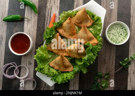 Kartoffel-Samosa-Snacks mit strukturiertem Hintergrund. Indisches Ramadan-Essen, Pakistanische Iftar-Mahlzeit. Stockfoto