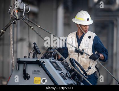 220809-F-LN908-0217 INDISCHER OZEAN (9. August 2022) Boatswain's Mate 2. Class Jalen Stewart, aus Belleville, Illinois, sichert ein starres Schlauchboot (RHIB) zu einem Kran an Bord der Lewis B. Puller-Class Expeditionseebasis USS Hershel 'Woody' Williams (ESB 4), 9. August 2022. Hershel 'Woody' Williams ist rotierend in den USA stationiert Marinestreitkräfte Afrika Einsatzgebiet, angestellt von den USA Sechste Flotte, um die Interessen der USA, Verbündeten und Partner zu verteidigen. Stockfoto