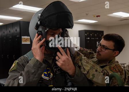 Airman 1. Klasse Gilberto Deleon, 8. Kampfgeschwader Flugausrüstung Auszubildender, hilft Colonel Justin Spears, 49. Wing Commander, seine Ausrüstung am 9. August 2022 auf dem Luftwaffenstützpunkt Holloman, New Mexico, vor dem Flug zu überprüfen. Hollomans F-16-Trainingsgeschwader absolvieren jedes Jahr etwa 180 Piloten und absolvieren mehr als 10.800 Stipendien. Stockfoto