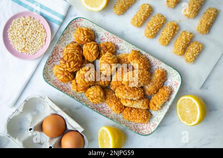 Penellets. Kleine Süßigkeiten verschiedener Formen, aus Mandel- und Kartoffelteig hergestellt und mit Mandeln oder Pinienkernen bedeckt. Stockfoto