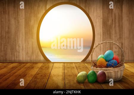 Farbenfrohe ostereier in einem Holzkorb auf dem Holzboden. Osterei-Konzept Stockfoto