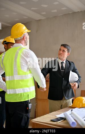 Selbstbewusster und erfolgreicher weißer Geschäftsmann im formellen Geschäftsanzug, der während des Treffens bei Constr Stockfoto