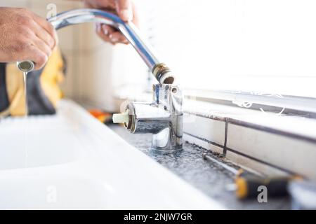 Klempner, Wasserhahn und Sanitär, Wartung mit Arbeitern und handwerkern, Hausrenovierung mit Handwerk und Reparaturen. Bauarbeiter, Handwerker in der Küche oder Stockfoto