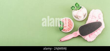 Wellness- und Spa-Zusammensetzung mit rosafarbenen natürlichen Zutaten. Kosmetische Schönheits-Hautpflege im Hintergrund. Trendiges Savannahgrün, flach liegend, Banner Stockfoto