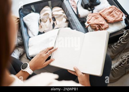 Reisen, Koffer und Notizbuch mit Frauenhänden für Planung, Urlaub und Verpackung von Kleidung. Reise, Gepäck und Abenteuer mit Zeitschriftenplaner und Stockfoto