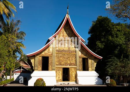 Laos: Szenen aus dem Hinduepic Ramayana (Lao: Phra Lak Phra Lam) schmücken das königliche Kutschhaus oder die Bestattungskapelle, Wat Xieng Thong (Goldener Stadttempel), Luang Prabang. Wat Xieng Thong mit seinen flachen, weitläufigen Dächern verkörpert den klassischen Luang Prabang-Stil, wurde 1560 von König Setthathirat (1548–71) erbaut und bis 1975 von der Monarchie bevormundet. Luang Prabang war früher die Hauptstadt eines Königreichs mit demselben Namen. Bis zur kommunistischen Machtübernahme im Jahr 1975 war es die königliche Hauptstadt und der Sitz der Regierung des Königreichs Laos. Die Stadt gehört heute zum UNESCO-Weltkulturerbe Stockfoto