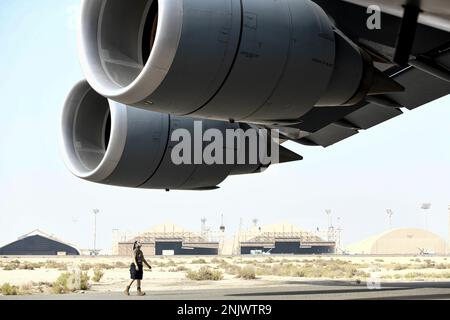 Ein dem 60. Flugzeuginstandhaltungsgeschwader zugeordnetes Luftfahrzeug inspiziert die Triebwerke einer Lockheed C-5M Super Galaxy, die dem 22. Luftwaffengeschwader am 10. August 2022 am Luftwaffenstützpunkt Al Dhafra, Vereinigte Arabische Emirate, zugeteilt wurde. Die C-5 flog nach Al Dhafra, um vier Reaper-Drohnen der General Atomics MQ-9 zu stationieren. Stockfoto