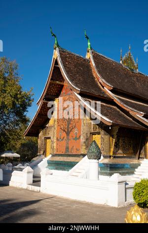 Wat Xieng Thong mit seinen flachen, weitläufigen Dächern verkörpert den klassischen Luang Prabang-Stil, wurde 1560 von König Setthathirat (1548–71) erbaut und bis 1975 von der Monarchie bevormundet. Luang Prabang war früher die Hauptstadt eines Königreichs mit demselben Namen. Bis zur kommunistischen Machtübernahme im Jahr 1975 war es die königliche Hauptstadt und der Sitz der Regierung des Königreichs Laos. Die Stadt gehört heute zum UNESCO-Weltkulturerbe. Stockfoto