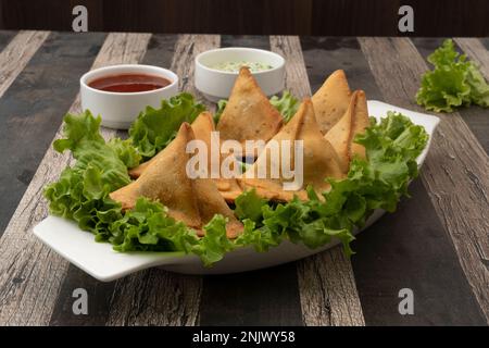 Kartoffel-Samosa-Snacks mit strukturiertem Hintergrund. Indisches Ramadan-Essen, Pakistanische Iftar-Mahlzeit. Stockfoto