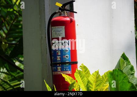 Rote Feuerlöscher an der Wand Stockfoto