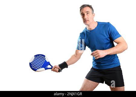 Porträt eines Mannes, der Paddeltennis spielt, mit einem Schläger in Position, um einen Ball zu empfangen, der blau-schwarze Sportkleidung und einen weißen isolierten Rucksack trägt Stockfoto
