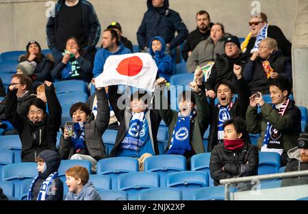 Japanische Fußballfans jubeln als ihr Held, und der Name des Brighton-Fußballers Kaoru Mitoma wird vor dem Spiel Brighton and Hove Albion gegen Fulham – Premier League im American Express Community Stadium, Brighton, genannt. Samstag, 18. Februar 2023 - Stockfoto