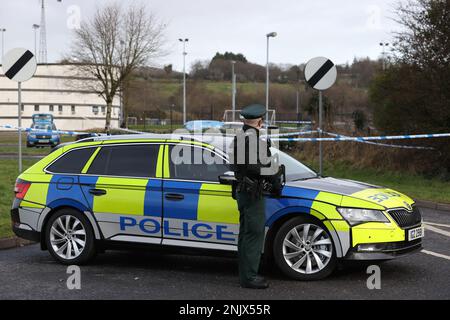 Einem bewaffneten Offizier der Polizei von Nordirland (PSNI) im Dienst in der Nähe des Sportkomplexes in der Region Killyclogher Road in Omagh, Co Tyrone, Wo der Detektivinspektor John Caldwell außerhalb seines Dienstes mehrmals von maskierten Männern vor jungen Leuten erschossen wurde, die er trainiert hatte. Herr Caldwell befindet sich nach dem Angriff am Mittwochabend im Krankenhaus in einem kritischen, aber stabilen Zustand. Foto: Donnerstag, 23. Februar 2023. Stockfoto