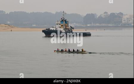 Trheintayuno Schlepper, gelistet als Feuerwehrschiff auf dem Weg zu einem Schiff mit einem kantabrischen trainera Ruderboot in der Santander Bay Cantabria Spanien Stockfoto