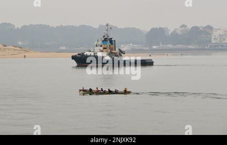 Trheintayuno Schlepper, gelistet als Feuerwehrschiff auf dem Weg zu einem Schiff mit einem kantabrischen trainera Ruderboot in der Santander Bay Cantabria Spanien Stockfoto