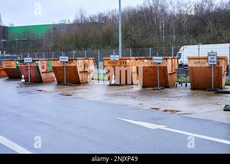 Orangene Müllcontainer mit Beschriftung für die Müllart die abgegeben werden darf. Stockfoto