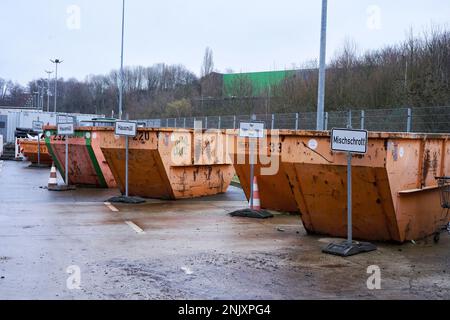 Orangene Müllcontainer mit Beschriftung für die Müllart die abgegeben werden darf. Stockfoto