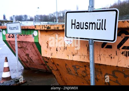 Orangene Müllcontainer mit Beschriftung für die Müllart die abgegeben werden darf. Hausmüll. Stockfoto