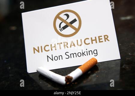 Kaputte Zigarette und Schild „Nichtraucher“ Stockfoto