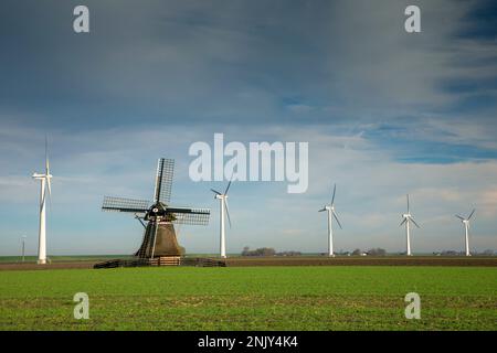 Windmühle zwischen Windrädern am Deich, Niederlande, Frisia, Ferwert Stockfoto