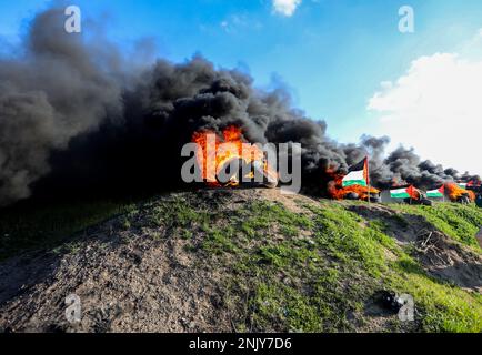 Gaza-Stadt, Gaza-Streifen, Palästina. 22. Februar 2023. Gaza, Palästina. 22. Februar 2023. Die Palästinenser verbrennen während eines Protests nahe der Grenze zwischen Israel und Gaza, östlich von Gaza-Stadt, gegen den israelischen Militärangriff auf die Stadt Nablus im Westjordanland Reifen. Mindestens 10 Palästinenser wurden getötet und Dutzende verletzt, als die israelische Armee am Mittwoch die Stadt Nablus im Westjordanland stürmte (Kreditbild: © Yousef Mohammed/IMAGESLIVE via ZUMA Press Wire), NUR REDAKTIONELLE VERWENDUNG! Nicht für den kommerziellen GEBRAUCH! Stockfoto