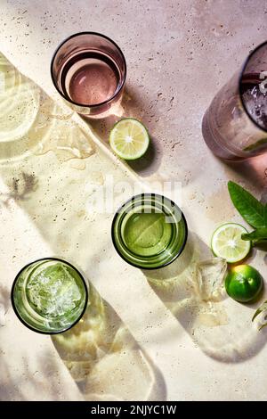 Von oben genießen Sie einen erfrischenden Mojito-Cocktail mit Eiswürfeln, Limette und Minze, die an sonnigen Sommertagen draußen platziert werden Stockfoto