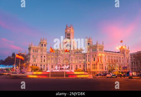 Beleuchteter historischer Palast mit leuchtenden Lichtern am Plaza de Cibeles in Madrid am Abend Stockfoto