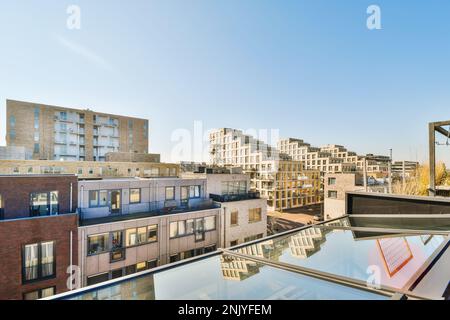 Außenansicht zeitgenössischer Wohngebäude mit Fenstern, die sich in der Stadt vor dem blauen Himmel befinden Stockfoto