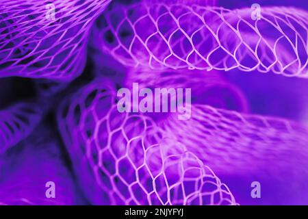 Nahaufnahme des Hintergrunds einer hellvioletten Netztextur mit vielen Löchern vor unscharfem Hintergrund Stockfoto