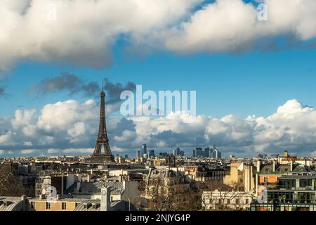 Sonnenschein über dem Eiffelturm und dem Geschäftsviertel La Defence mit Blick auf die Dächer von Paris in Frankreich Stockfoto