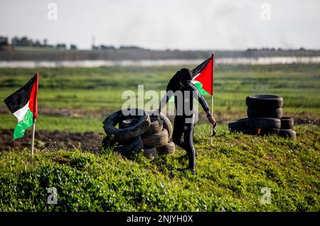 Gaza-Stadt, Gaza-Streifen, Palästina. 22. Februar 2023. Gaza, Palästina. 22. Februar 2023. Die Palästinenser verbrennen während eines Protests nahe der Grenze zwischen Israel und Gaza, östlich von Gaza-Stadt, gegen den israelischen Militärangriff auf die Stadt Nablus im Westjordanland Reifen. Mindestens 10 Palästinenser wurden getötet und Dutzende verletzt, als die israelische Armee am Mittwoch die Stadt Nablus im Westjordanland stürmte (Kreditbild: © Yousef Mohammed/IMAGESLIVE via ZUMA Press Wire), NUR REDAKTIONELLE VERWENDUNG! Nicht für den kommerziellen GEBRAUCH! Stockfoto