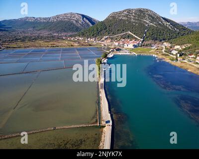 Draufsicht über die Salzpfanne in der Stadt Ston in Kroatien. Befestigte Mauern in den Hügeln im Hintergrund. Salzfelder. Ston Salt Arbeitet. Stockfoto