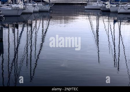 Reflexion des Abendhimmels und der Masten der Yachten vor der Küste am Gardasee in Italien Stockfoto