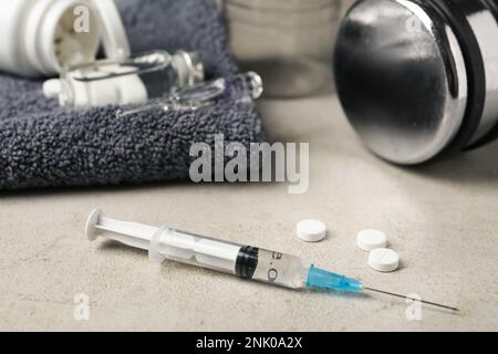 Verschiedene Medikamente in der Nähe von Handtüchern und Sportgeräten auf dem Lichttisch. Dopingkontrolle Stockfoto