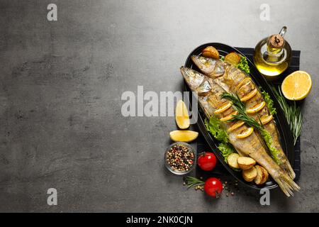 Leckere hausgemachte Hecht-Sitzstangen auf grauem Tisch, flach liegend und Platz für Text. Flussfische Stockfoto