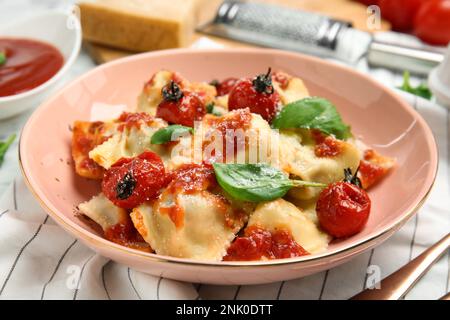 Leckere Ravioli mit Tomatensauce, serviert auf dem Tisch, Nahaufnahme Stockfoto