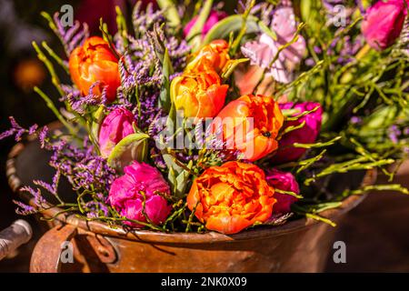 Verschiedene Blumen und Setzlinge in der Nähe des Eingangs zum Blumenladen, Frühling, osterkonzept Stockfoto