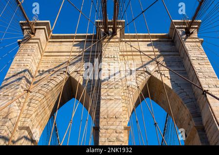 Details zu einem Steinpier der Brooklyn Bridge in New York City mit Metallkabeln. An einem sonnigen Sommertag ohne Leute aus Bellow genommen Stockfoto