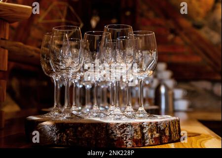 Polierte und glänzende Weingläser auf einer böhmischen rustikalen Party auf einem Baumstamm-Stand Stockfoto